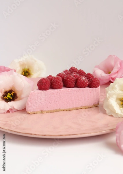 Fototapeta Raspberry cheesecake with berries and fresh flowers on pink plate food photo, sweet cake food photo art, kitchen, menu and restaurant photoshoot