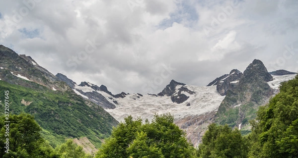 Fototapeta Beautiful landscape of glacier in summer season. Glacier mountain with green vegetation on high ground in cloudy weather.