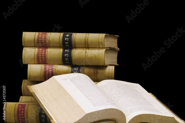 Fototapeta A stack of old law reports on a black background.