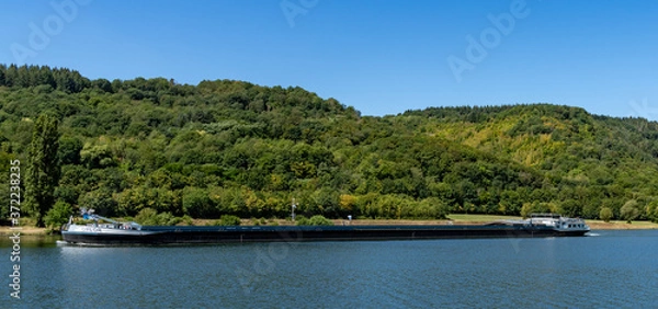 Fototapeta large river barge transporting goods on the Moselle River near Enkirch