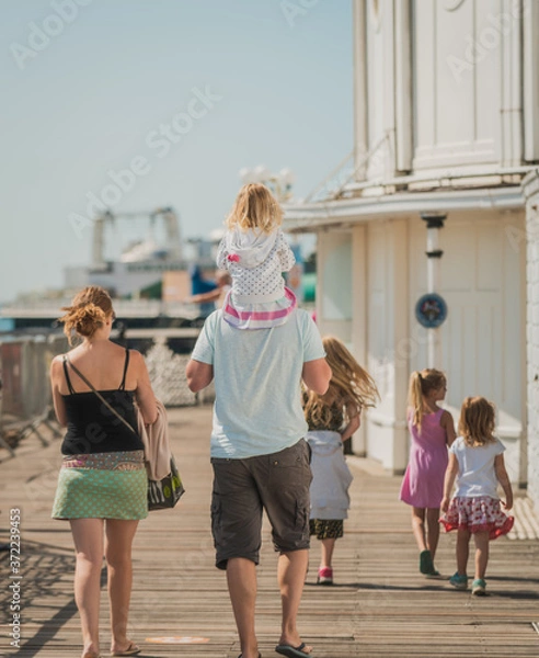 Obraz Family of 6 enjoy a day out at Brighton Beach Pier during the Covid-19 pandemic 