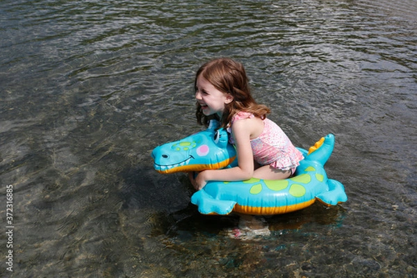 Obraz happy laughing girl enjoying swimming in sea with rubber ring crocodile