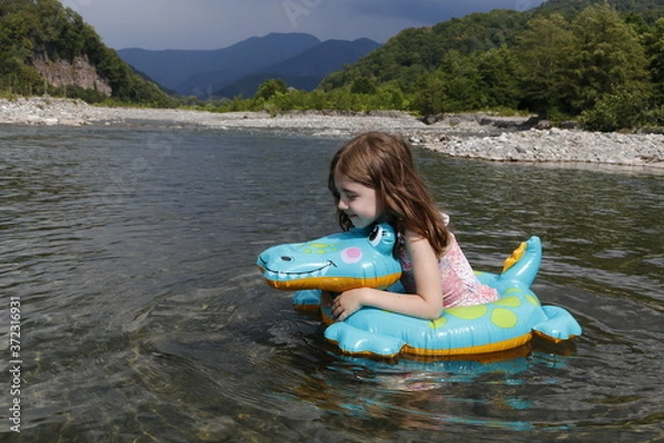 Obraz happy laughing girl enjoying swimming in river with rubber ring crocodile