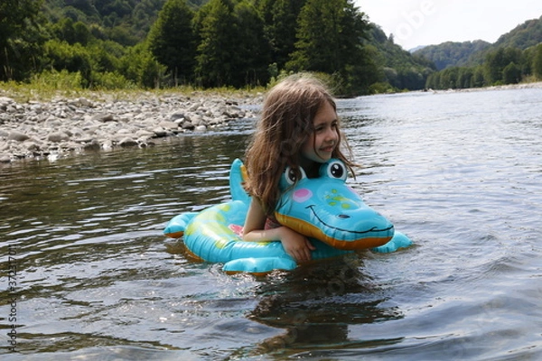 Obraz happy laughing girl enjoying swimming in river with rubber ring crocodile