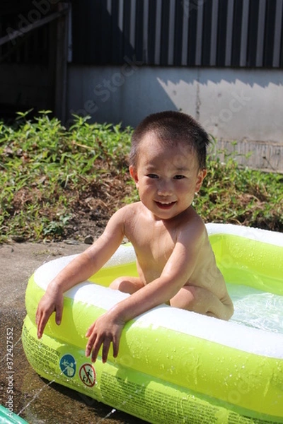 Obraz ビニールプールで遊ぶ日本の男の子（3歳児）