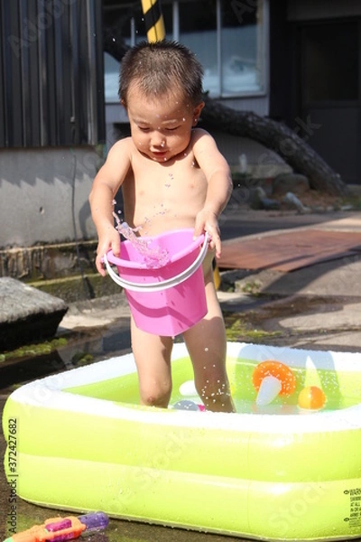 Obraz ビニールプールで遊ぶ日本の男の子（3歳児）