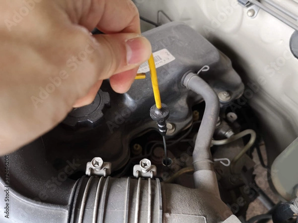 Fototapeta The engine oil level dipstick is pulled.