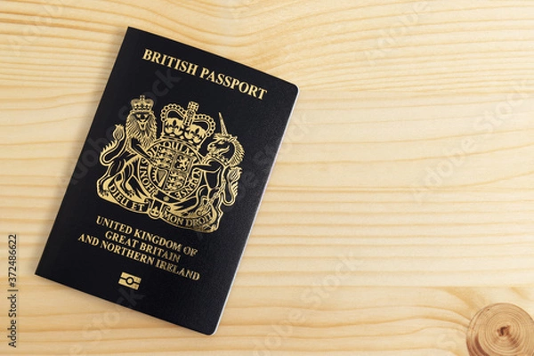 Fototapeta London, UNITED KINGDOM - AUGUST 17, 2020: New British Passport Edition released in March 2020 after Brexit laid on desk, citizenship newsworthy