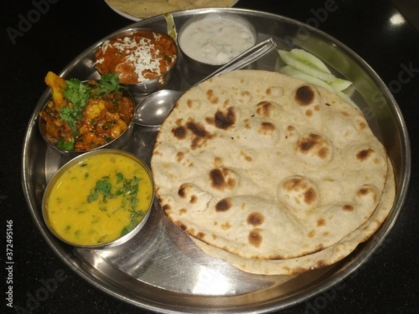 Obraz Typical vegetarian thali provided by the office canteen staff. Punjabi food with big round flatbread.