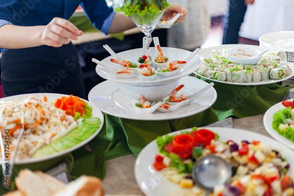 Fototapeta Turystyczne statki wycieczkowe pływające wśród wapiennych gór w zatoce Halong w Wietnamie, bufet w restauracji na statku wycieczkowym