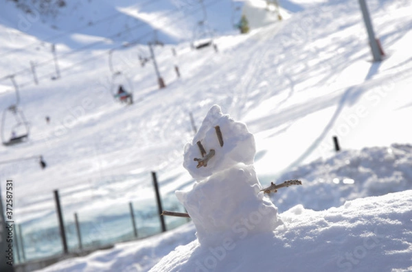 Obraz small snowman with snowy slope in the background