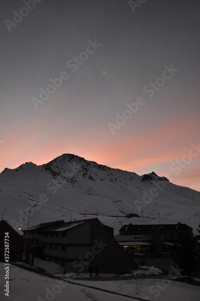 Obraz winter sunset over snowy mountain and the moon in the background