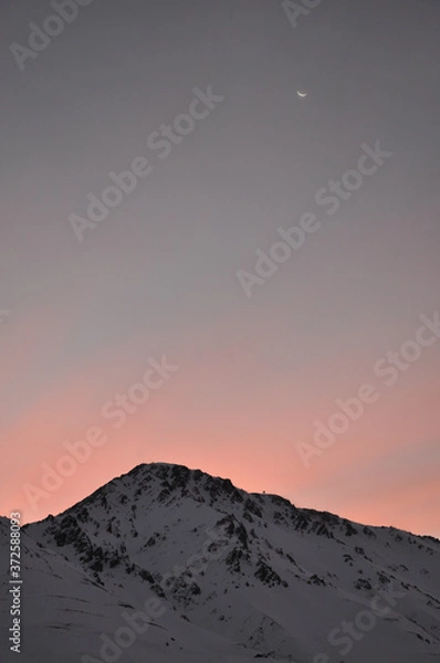 Obraz winter sunset over snowy mountain and the moon in the background