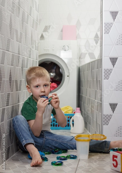 Obraz Kid plays and eats deadly capsules for washing