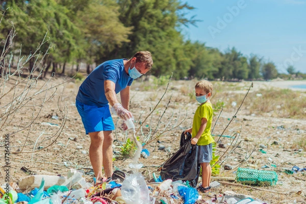 Fototapeta Volunteer blue face mask forest sand beach. Son helps father hold black bag for pick up garbage. Problem spilled rubbish trash planet pollution environmental protection. Natural children education