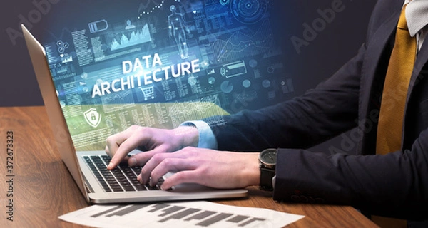 Fototapeta Businessman working on laptop with DATA ARCHITECTURE inscription, cyber technology concept