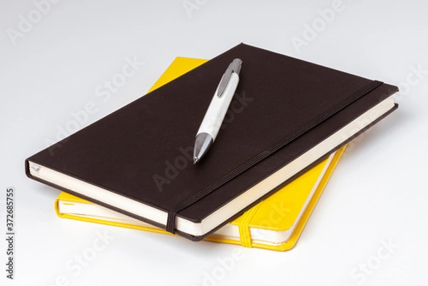 Fototapeta Carnets de note jaune et noir avec un stylo posé
