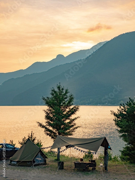 Fototapeta 湖畔のキャンプ風景と夕日