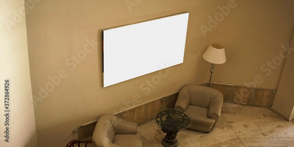 Fototapeta empty white picture hanging on concrete wall in hotel hall interior