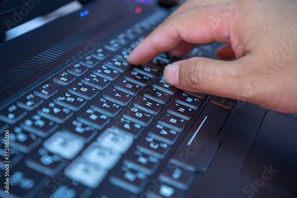 Obraz man typing on a laptop keyboard