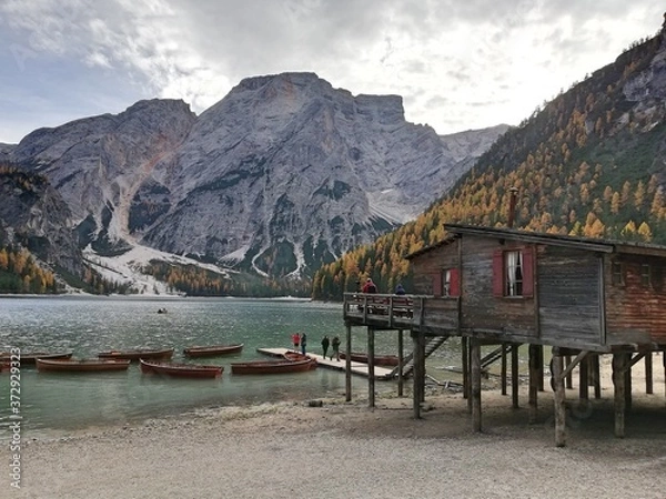 Fototapeta Jetty in lake between mountains, jetty in italy, boats in empty lake, Braies lake