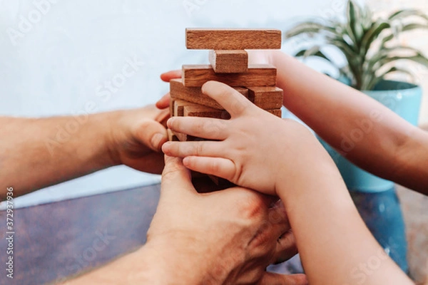 Obraz Father and child playing game tumble tower from wooden block
