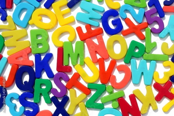 Fototapeta Many english letters lie on a white background