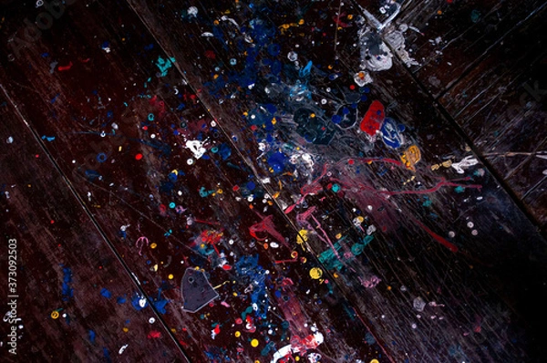 Fototapeta Drops of oil paint on a wooden background for a dark background.