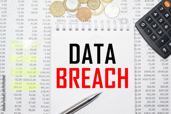 Obraz DATA BREACH on the block on the background of financial reporting, coins, calculator, pens and yellow stickers. Business concept