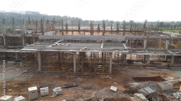 Obraz SERDANG, MALAYSIA -JUNE 13, 2016: Construction site in progress at Serdang, Malaysia during the daytime. Workers busy with their task installing formwork and reinforcement bar.    