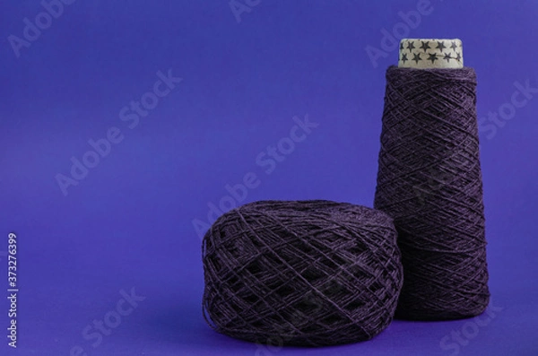 Obraz cone and ball of purple wool yarn on blue background. copy space
