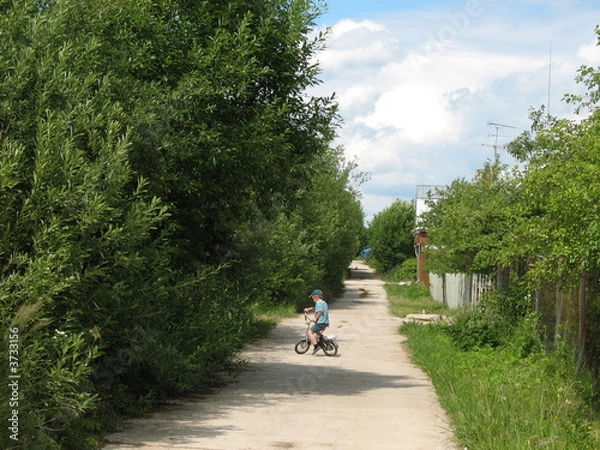 Fototapeta A boy on a bicycle rode on the road