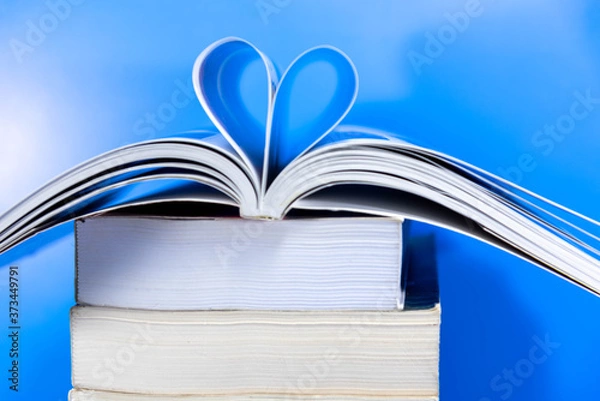 Obraz Stack of paper books on blue background