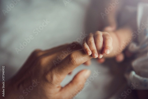 Fototapeta Noworodek trzymając rękę matki.
