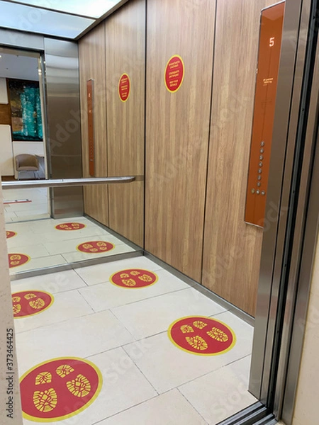 Obraz Social distance signs on the floor in the elevator