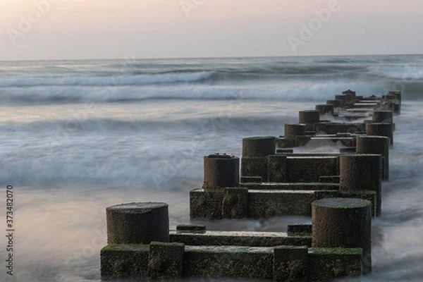 Obraz Ocean waves crashing into pylons 