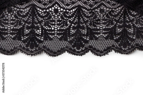Fototapeta Black lace texture with flowers on a white background. Background of black lace with a flower pattern on a white background. Black guipure. Black fabric with an ornament