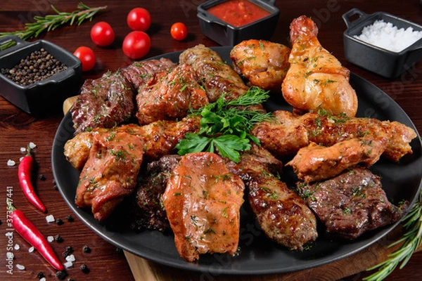 Fototapeta Assorted delicious grilled meat with vegetable. Mixed grilled bbq meat with vegetables. Set of shish kebabs or barbecue shashlik collection. Baked potatoes and fresh tomatoes. 