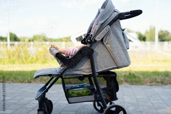 Fototapeta baby's foot is visible from  stroller, child for  walk