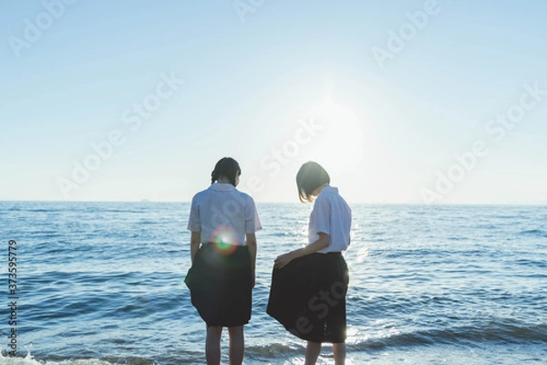 Obraz 夕暮れの海にいる女子高生