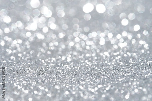 Fototapeta Silver Sparkling Lights Festive background with texture. Abstract Christmas twinkled bright bokeh defocused and Falling stars. Winter Card or invitation	