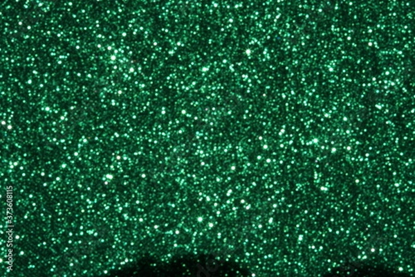 Fototapeta Green Sparkling Lights Festive background with texture. Abstract Christmas twinkled bright bokeh defocused and Falling stars. Winter Card or invitation	