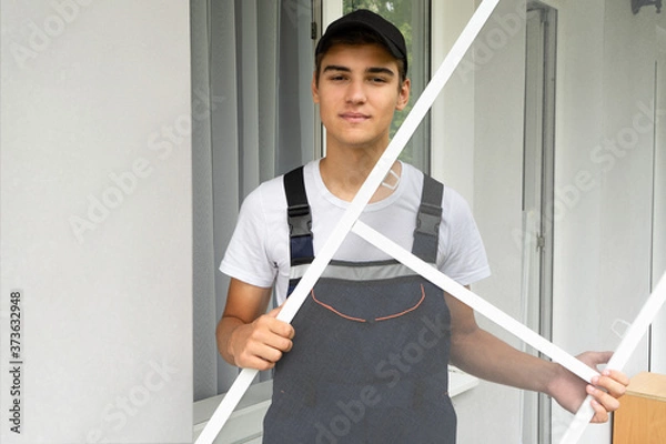 Obraz Man installs a mosquito net in the apartment. Protection from flying insects