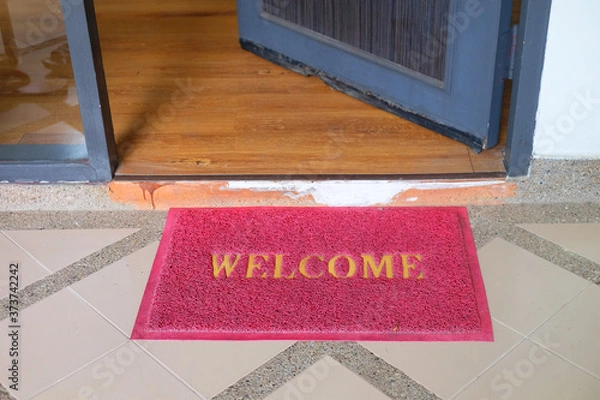 Fototapeta Red welcome doormat in front of opening door