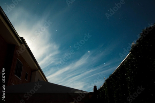 Obraz Foto de larga exposición de noche estrellada y edificios