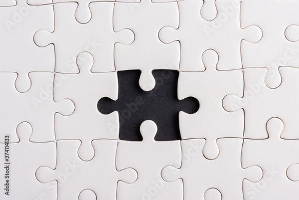 Obraz Top view flat lay of paper plain white jigsaw puzzle game texture incomplete or missing piece, studio shot on a black background, quiz calculation concept