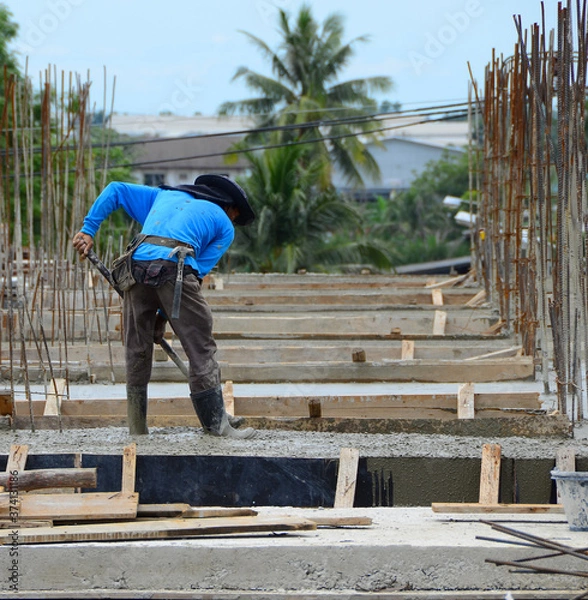 Fototapeta Construction workers are using the newly poured cement spreaders of crane into the ground to allow ordinary cement concrete with a thickness determined by the engineer and a smooth uniform surface.