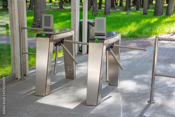 Fototapeta Steel automatic turnstile with arrows for access to the public park