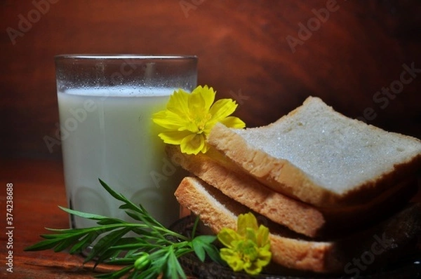 Fototapeta Dry rusk bread and a glass of milk isolated on wooden background. Healhty breakfast menu