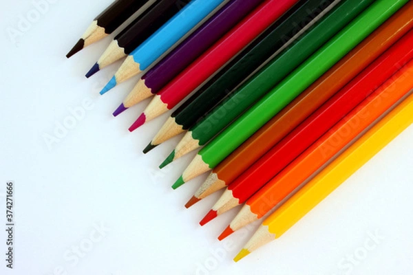 Fototapeta Colored pencils on white background. Many different colored pencils. Color pencil. Pencils are sharp. Pencils placed diagonally in the upper-right corner. Close-up. Copy space. Background. Flatlay